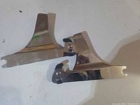 Both chrome bracket mounts laid flat showing overall shape and finish