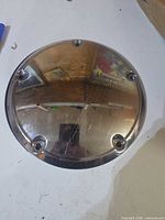 Front chrome face of derby cover with five mounting holes visible