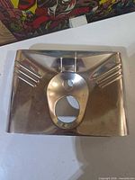 Front view of chrome panel cover showing central cut-outs and ribbed accents