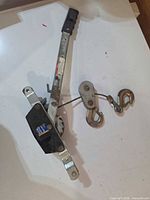 Full view of cable puller showing handle, ratchet mechanism, cable and hooks