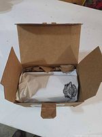 Box opened showing wrapped fork slider cover with Harley-Davidson logo