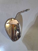 Front view of chrome oval mirror showing reflective glass and stem