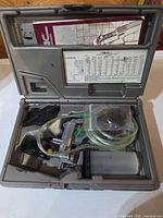 Open carry case showing pump, reservoir, tubing, adapters, manual and instruction card