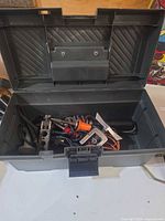 Open gray plastic toolbox with assorted tools visible