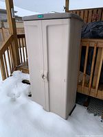 Beige Jardin vertical shed front view on deck in snow