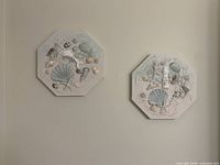Two octagon shell plaques on wall