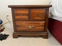 Front view of one nightstand showing drawer arrangement and hardware