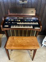 Front view of Hammond console organ with bench and lamp
