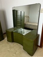 Full view of olive green vanity with attached mirror
