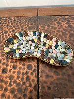 Top view showing multicolor mosaic tile pattern on gold-tone tray