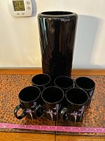 Group shot of six mugs and vase with ruler for scale