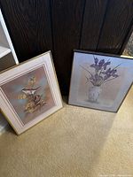 Both framed prints leaning against wall