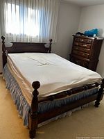 Full view of assembled queen bed frame with mattress and box spring
