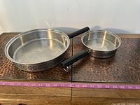 Both frying pans side by side on surface showing size and handles