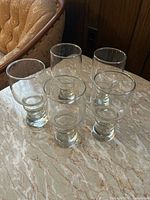 Five clear footed glasses on tabletop