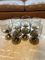 Front view of all seven smoked gray goblets displayed on tabletop