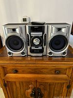 Front view of Sony MHC-EC55 system with speakers and remote on top