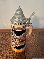 Front view showing stein, pewter lid closed, relief chalet scene and inscription