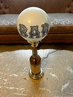 Full view of table lamp showing globe, bottle base, cord