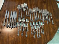 Entire flatware set laid out by type on table