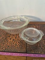 Large and small clear Pyrex bowls side by side showing shape and handles