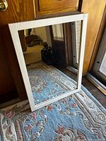 Front view of rectangular mirror with white wood frame