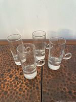 four clear glass shot glasses on table