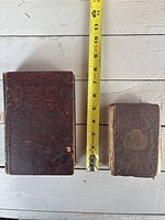 Front view of both cookbooks with tape measure for scale