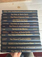 Stacked view showing all thirteen book spines with titles and Cadillac imprint