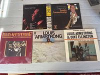 Five Louis Armstrong LPs including Satchmo Serenades, The Immortal Louis Armstrong, Giants of Jazz, self-titled beach cover and Louis Armstrong & Duke Ellington.