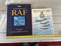 Front covers of both hardcover books with tape measure showing size