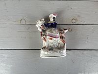 Woman on ram Staffordshire figurine