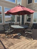 Full patio set showing table, four chairs and maroon umbrella