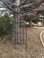 Full view of trellis standing upright against tree
