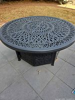 Top view of round black metal lattice fire pit table