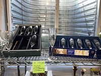 Two boxed sets of crystal flutes displayed on shelving, showing overall lot