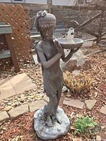 Front view of girl statue with bird on bowl