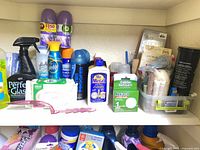 Shelf with 16+ assorted cleaning products including sprays, aerosols, wipes and bottles