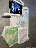 Rolled posters, laminated world map, unfolded topo maps