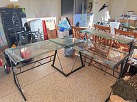 Overall view of disassembled metal and glass L-shaped desk