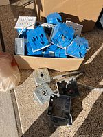Box of blue plastic boxes and white duplex outlets