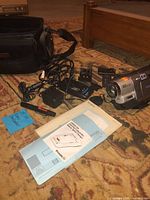 Overall lot showing camcorder, chargers, cables, bag and manual
