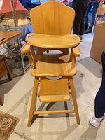 Full view of wooden high chair with tray inserted