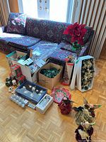 Group shot of entire lot on floor showing ornaments, angels, garland, vase, swag and snow globe