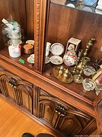 Overall lot in cabinet showing candlesticks, jar, boxed cups, coaster sets
