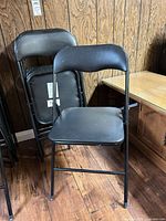 Front chair unfolded, additional chairs stacked behind, showing overall design and color