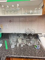 Countertop view with highballs, shot glasses, beer mugs, goblets