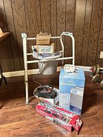 All items grouped: commode, dehumidifier box, tote bag, alarm clock, cardboard box, red boxed item, dumbbells visible