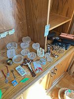 Overview of lot showing religious items, glass dishes, eyewear and cases