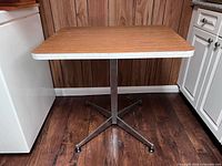 Front view showing full table with laminate top and metal pedestal base